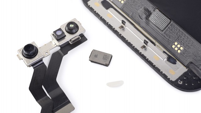 The new chip next to the cameras, display and a grain of rice (image: iFixit)
